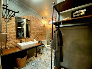 a bathroom with a sink and a brick wall at House of Machine Boutique Hotel in Bangkok