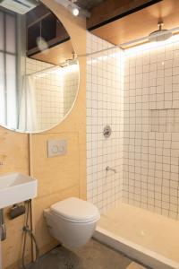 a bathroom with a toilet and a shower and a sink at HomeBase Kapitolyo - Minimalist Serviced Apartments in Manila