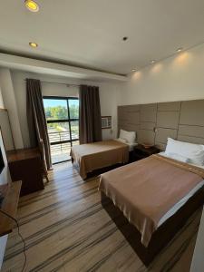 a hotel room with two beds and a balcony at North Stellar Hotel and Events-Place in Batac