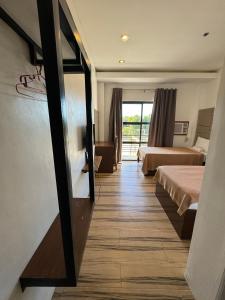 a hotel room with two beds and a mirror at North Stellar Hotel and Events-Place in Batac