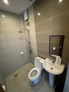 a bathroom with a toilet and a sink at North Stellar Hotel and Events-Place in Batac