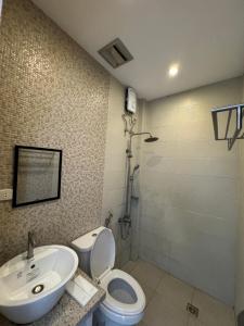 uma casa de banho com um lavatório, um WC e um chuveiro em North Stellar Hotel and Events-Place em Batac