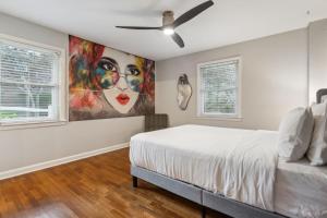 1 dormitorio con 1 cama y una pintura en la pared en Spacious 4BR Retreat in Vibrant Smyrna Near Lakes, en Smyrna