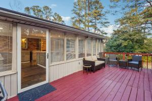 a wooden deck with chairs and a kitchen on it at Spacious 4BR Retreat in Vibrant Smyrna Near Lakes in Smyrna