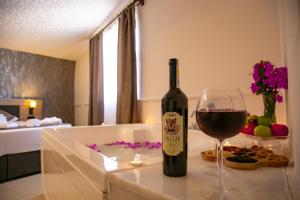 uma garrafa de vinho e um copo sobre uma mesa em Bloomtalya Hotel em Antalya