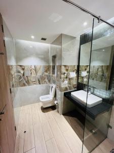 a bathroom with a toilet and a glass shower at Luxury Studios Key 1 in Gurgaon
