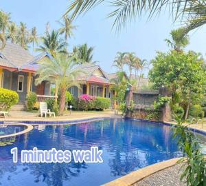 a villa with a swimming pool in a resort at Popular Lanta Resort in Ko Lanta