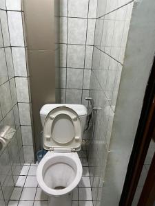 a bathroom with a white toilet in a stall at Joel House deido in Douala