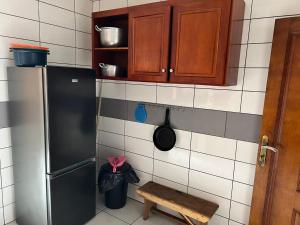 a kitchen with a black refrigerator and a wooden cabinet at Joel House deido in Douala