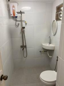 a bathroom with a shower and a toilet and a sink at Angelito's Beach House Siargao in General Luna