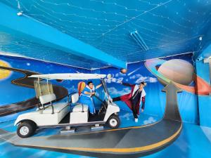 Uni-Resort Mawutu في Guanxi: غرفة فيها بطل و عربة جولف