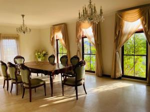 a dining room with a table and chairs and windows at 悉尼Killara Luxurious 8BR House 360 degree view in Saint Ives