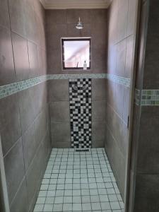 a bathroom with a shower with a window at Hope Lodge in East London