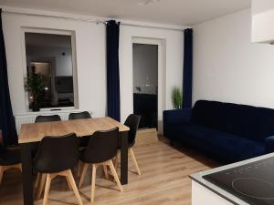 a living room with a table and a blue couch at Izery Apartamenty in Szklarska Poręba