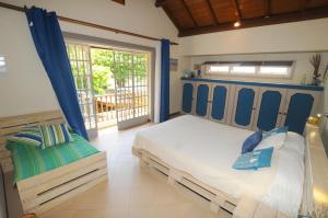 a bedroom with a bed and a chair in it at Villa Eastern Wind in Pointe d'Esny