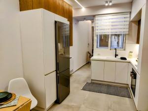 a kitchen with a refrigerator and a sink and a window at Elpis' cozy & luxury apartment in Athens