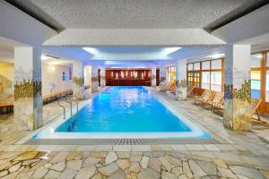 a large swimming pool in a hotel lobby at Rogla – Hotel Rogla in Resnik