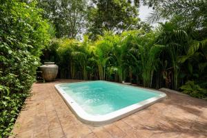 a swimming pool in the middle of a garden at New 3BR Chalet-Style Villa Pasak Paradise 3, Private Pool, 10min grive to Laguna Phuket in Ban Pak Lak