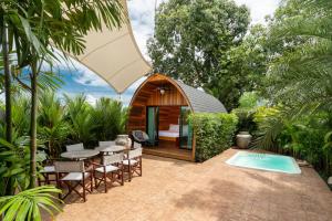 a small cabin with a table and chairs in a garden at New 3BR Chalet-Style Villa Pasak Paradise 3, Private Pool, 10min grive to Laguna Phuket in Ban Pak Lak