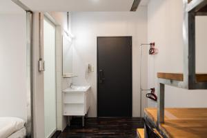 a bathroom with a black door and a sink at miniinn in Taipei