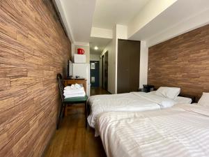 a hotel room with two beds and a wooden wall at La Foret Fujimi in Hiroshima