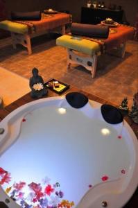 a living room with a white tub and two chairs at Suites Pipa Beleza Spa Resort in Pipa