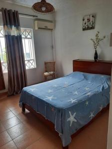a bedroom with a bed with a blue blanket on it at Luxury Apartment, 3 bedrooms, 1 minute walk to the beach in Trou aux Biches