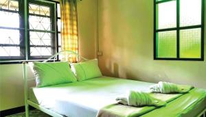 a bed in a room with two windows at Viewsuay Farsai Wangnamkaew in Wang Nam Khieo