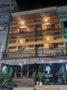 a large building with a balcony on top of it at Captain Joe Cafe & Hostel in Hua Hin