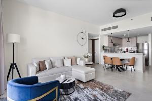 a white living room with a couch and a table at Spacious 1BR APT Wasl in Dubai