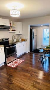 cocina con armarios blancos y nevera negra en Cargo7 Cozy suites2, en North Providence