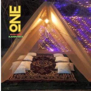 1 cama en una tienda de campaña con luces moradas en ONE 7 FARM (DESI PARADISE FARM ) en Dubái