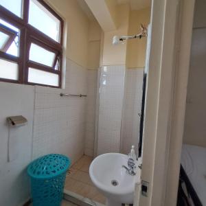 een badkamer met een wastafel, een toilet en een raam bij Ngara - Emeli in Nairobi