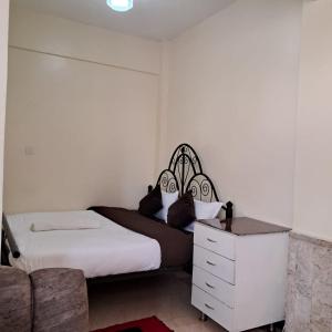 een slaapkamer met een bed en een dressoir bij Ngara - Emeli in Nairobi