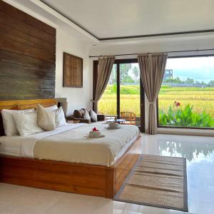 a bedroom with a bed and a view of a field at Kubu Bali Baik Villa & Resort - CHSE Certified in Ubud
