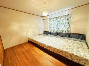 una camera da letto con un letto e una finestra di ヴィラ砂時計九十九里超豪華大型貸切別荘寝室五つペット可サウナ本格カラオケグランドピアノ麻雀 a Kujukuri