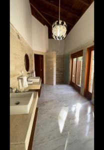 a large bathroom with two sinks and a chandelier at SrvittiniVillas Spacius Confort Villa Fam Team CouplesCasa de Campo Resort in La Romana
