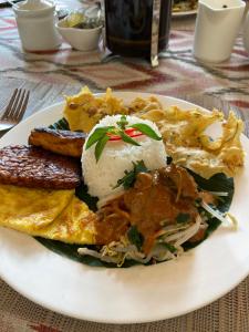 a plate of food with rice and other foods at Accessible Villa G in Sanur