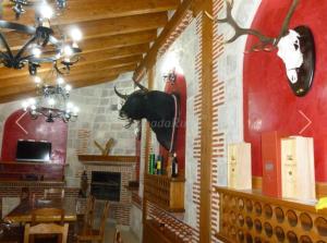 a dining room with a bulls head on the wall at Casa rural Puerta Villa in Villabrágima