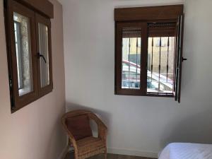une chambre avec une chaise et deux fenêtres dans l'établissement Robledo de Chavela plaza, à Robledo de Chavela