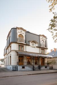 un gran edificio blanco con techo negro en GANZ HOTEL, en Ivano-Frankivsk