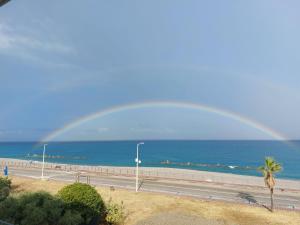 un arco iris sobre una carretera y el océano con una autopista en Apartments Miro' en Capo dʼOrlando