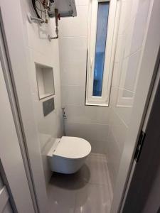 a small white bathroom with a toilet and a window at Modern flat in Central Prague in Prague