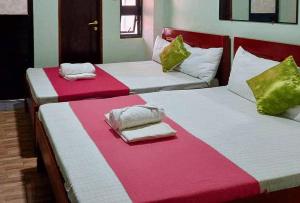 two beds in a room with red and white at RedDoorz @ Mary Land Transient Alaminos Pangasinan in Alaminos