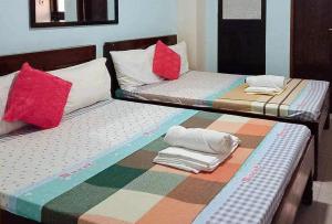two beds sitting next to each other in a room at RedDoorz @ Mary Land Transient Alaminos Pangasinan in Alaminos