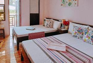 a hotel room with two beds and a table at RedDoorz @ Mary Land Transient Alaminos Pangasinan in Alaminos