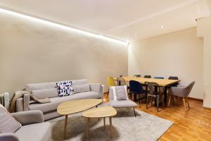 sala de estar con sofá, mesas y sillas en TuApartamento Centro Ciudad Calle Caldereria 12, en Pamplona