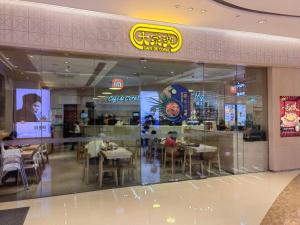 a restaurant with people sitting at tables in a cafeteria at 广州朴宿漫享公寓(琶洲国际会展中心店） in Guangzhou