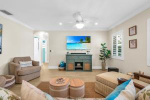 a living room with a couch and a tv at Grand Pool Villa Minutes to the Beach! Sleeps 8! in Boynton Beach