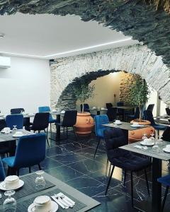 Hôtel Continental في باستيا: مطعم بطاولات وكراسي وجدار حجري